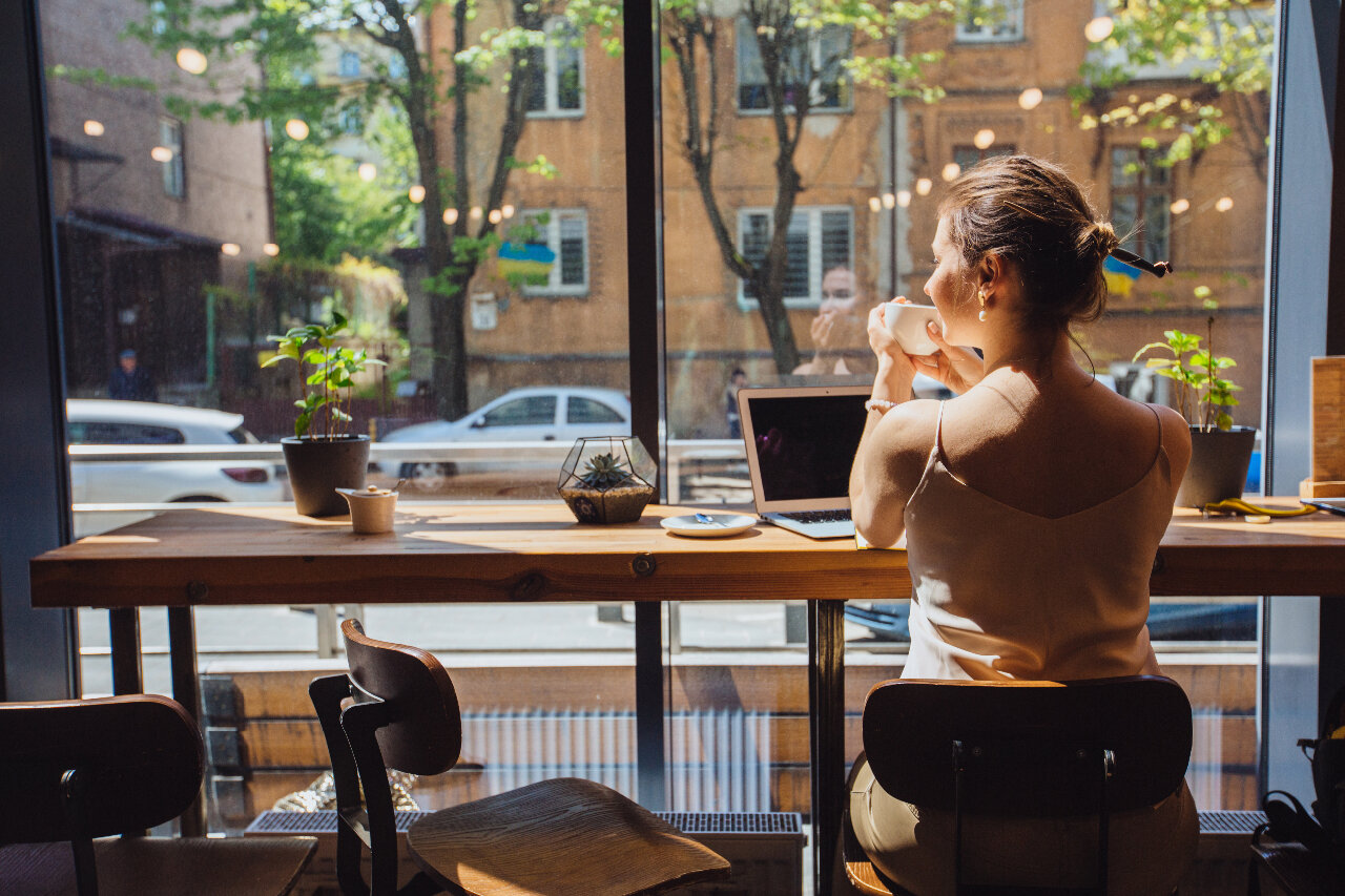 woman at restaurant dining alone looking outside